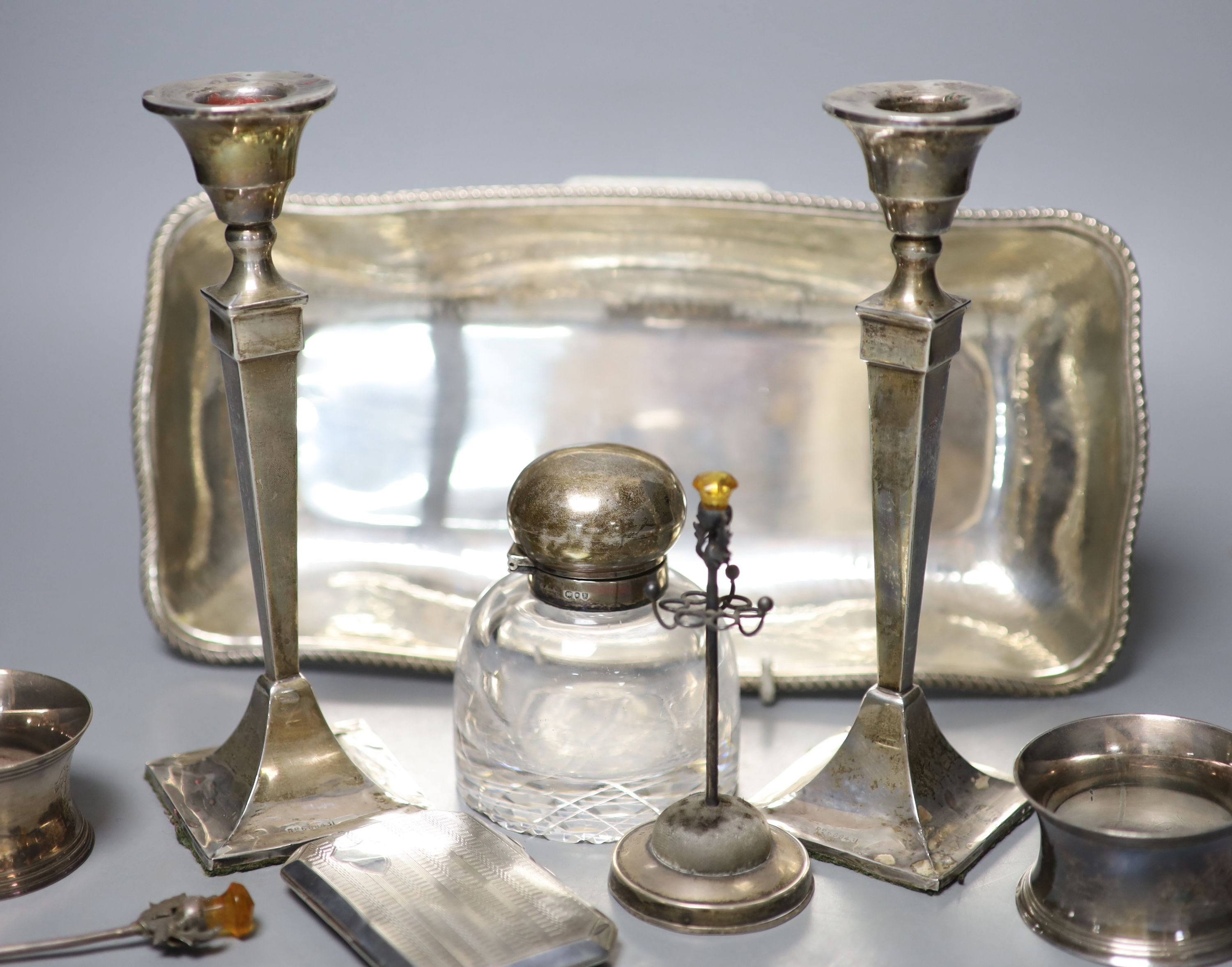 A pair of George V silver candlesticks (a.f.) and other small silver including a hat pin stand, cigarette case and 800 dish etc. and a pair of plated napkin rings.